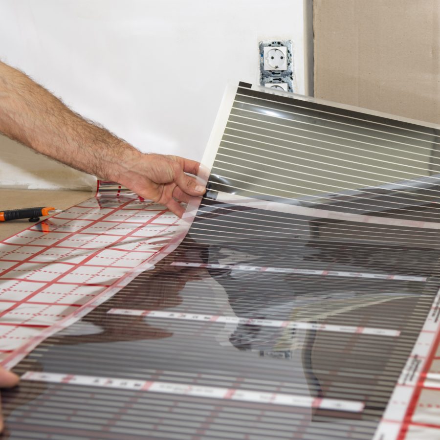 Elektriker legger varmefolie på gulv